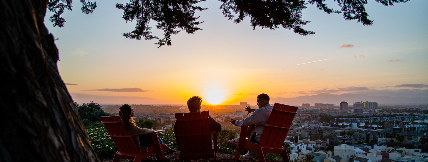 students watch the sunset from LMU's bluff